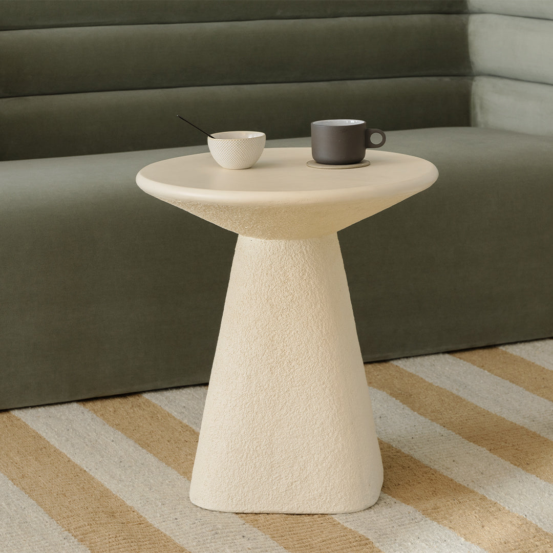 Table d'appoint minimaliste en béton ivoire avec plateau lisse et courbes douces pour le salon