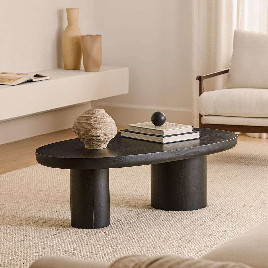 Table basse en frêne noir biologique avec plateau ovale et pieds cylindriques pour le salon