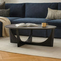 Table basse moderne noire en bois massif avec base sculpturale en arche et bords biseautés pour le salon