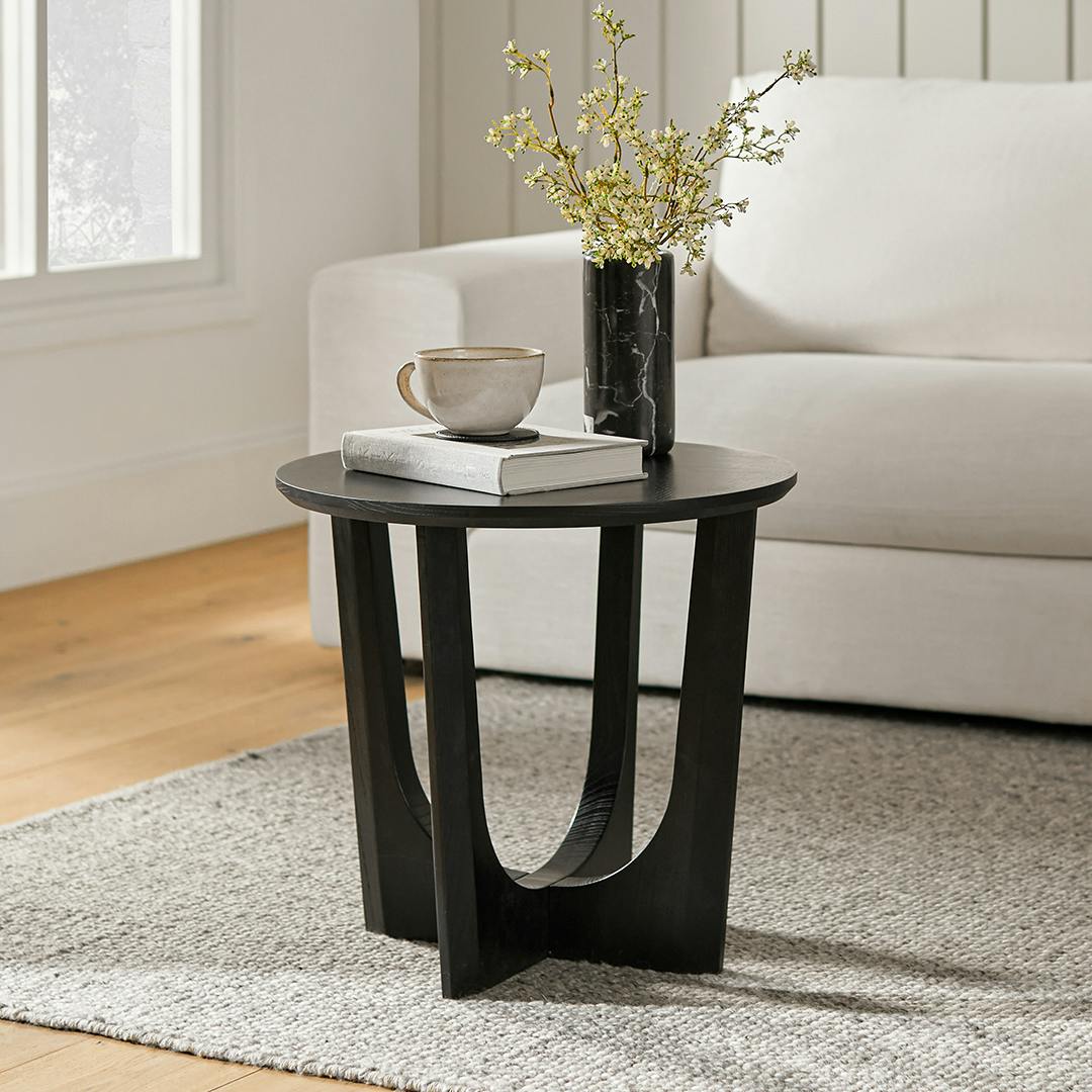 Table d'appoint moderne noire en bois massif avec base sculpturale en arche et bords biseautés pour le salon