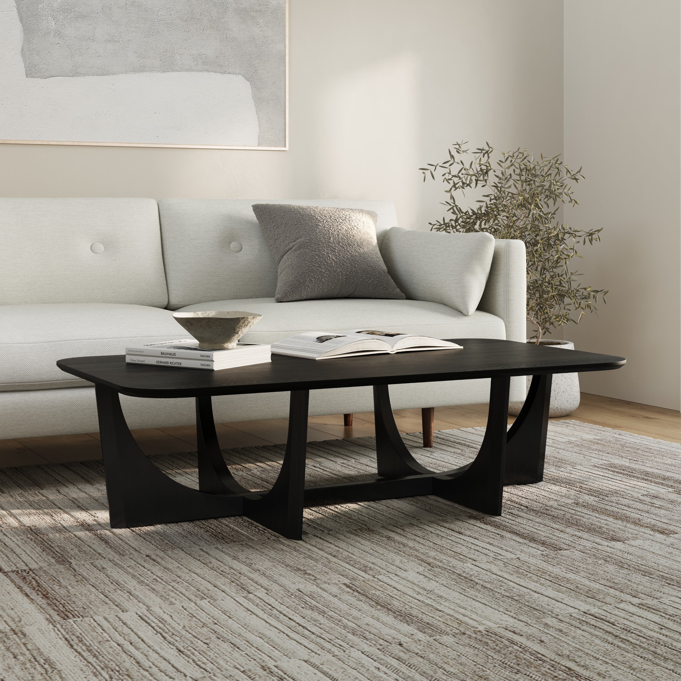 Table basse moderne noire en bois massif avec base sculpturale en arche et bords biseautés pour le salon